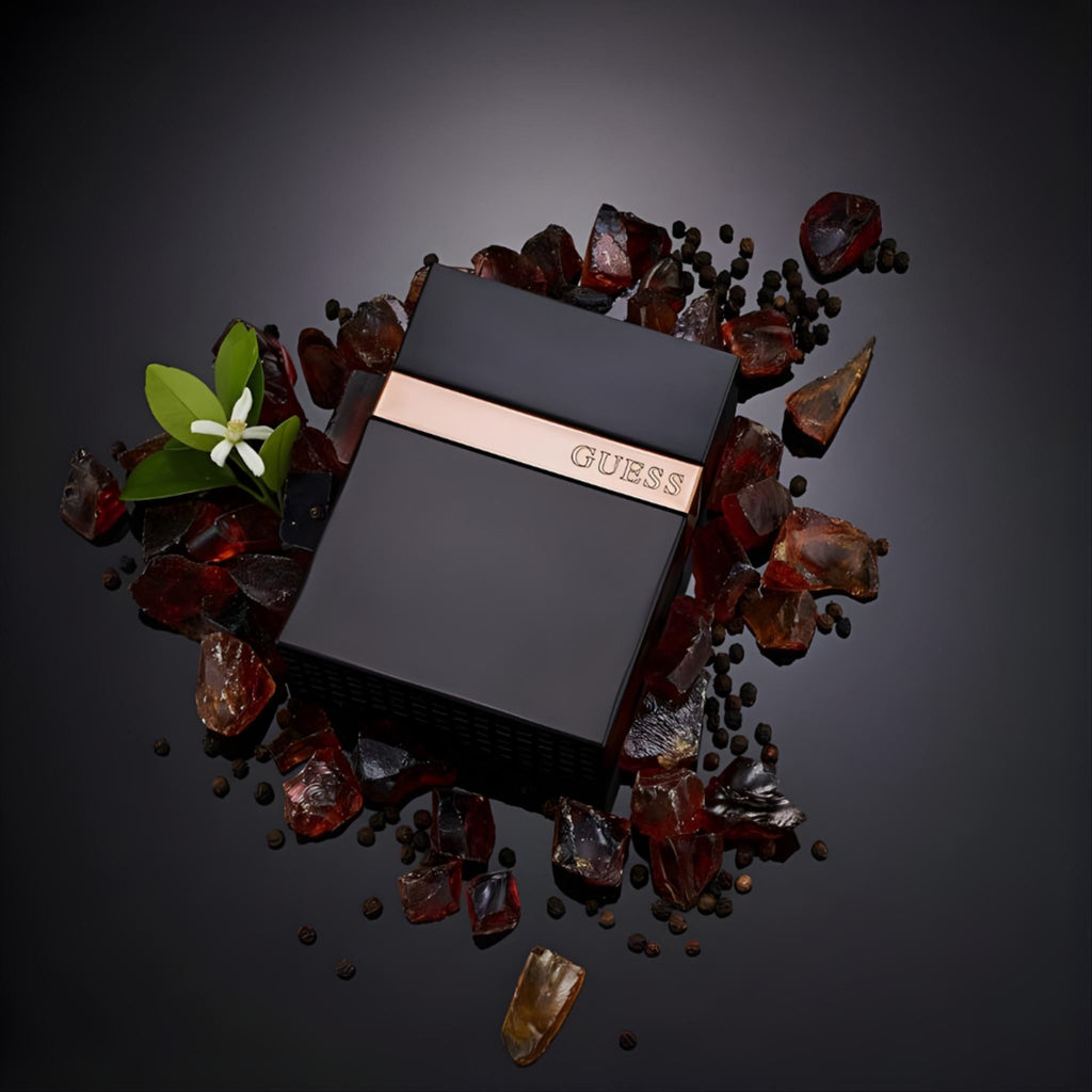 Refect Beauty Guess Seductive Noir for Men eau de toilette bottle surrounded by amber stones and peppercorns