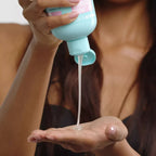 Refect Beauty Hair Burst shampoo being poured from a light blue bottle into a hand for hair care routine