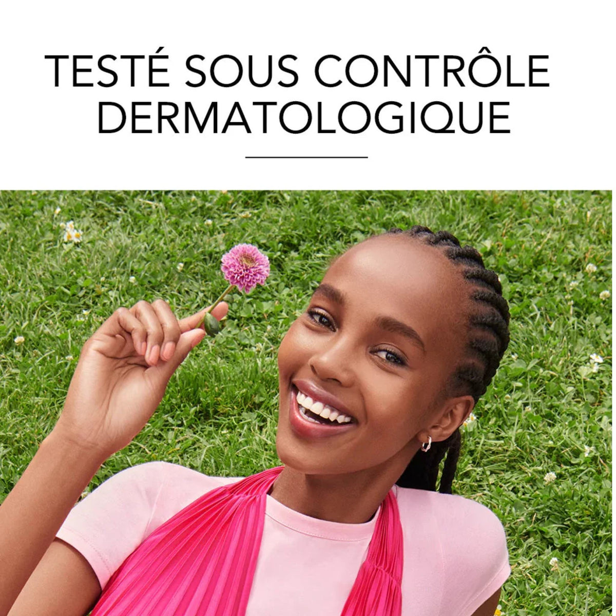Refect Beauty model with radiant skin smiling in a grassy field holding a pink flower, promoting dermatological care
