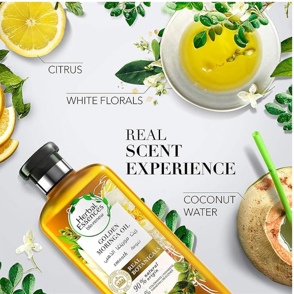 Refect Beauty Herbal Essences Golden Moringa Oil shampoo bottle surrounded by citrus, white florals, and coconut.