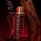 Refect Beauty Hugo Boss The Scent Elixir Parfum Intense bottle with red glass, gold cap, lavender, and wood accents.