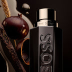 Refect Beauty Hugo Boss The Scent Magnetic perfume bottle with maninka fruit, bran, and vanilla husk on dark background