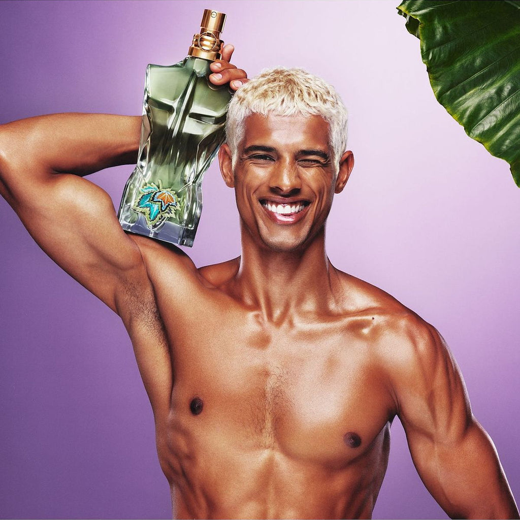 Refect Beauty model holding Jean Paul Gaultier Le Beau Paradise Garden perfume bottle against a purple background