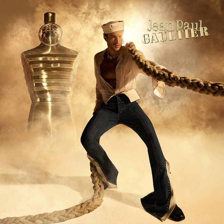Refect Beauty Jean Paul Gaultier Le Male Elixir Absolu perfume bottle next to a sailor model in a golden desert setting.
