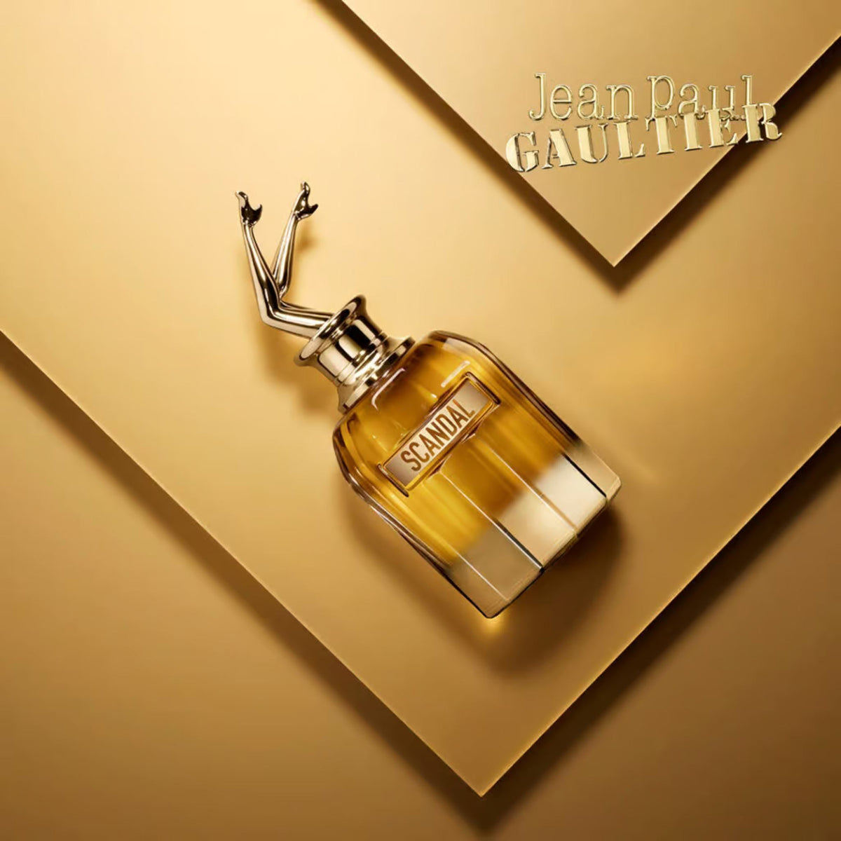 Refect Beauty Jean Paul Gaultier Scandal Absolu perfume bottle with iconic legs cap on a gold geometric background