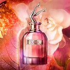Refect Beauty Jean Paul Gaultier Scandal perfume bottle with iconic legs cap against a floral and honey background