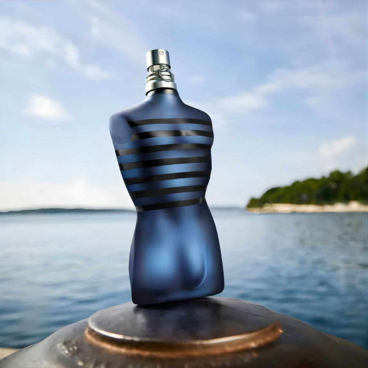 Refect Beauty Jean Paul Gaultier Ultra Male eau de toilette in a blue torso-shaped bottle against a coastal backdrop