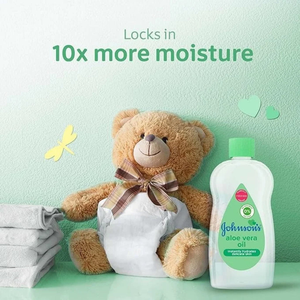 Refect Beauty Johnsons Aloe Vera Baby Oil bottle next to a cute teddy bear wearing a diaper on a soft green background
