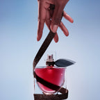 Refect Beauty Lancome La Vie Est Belle L'Elixir perfume bottle held by a hand with a dark glittery ribbon