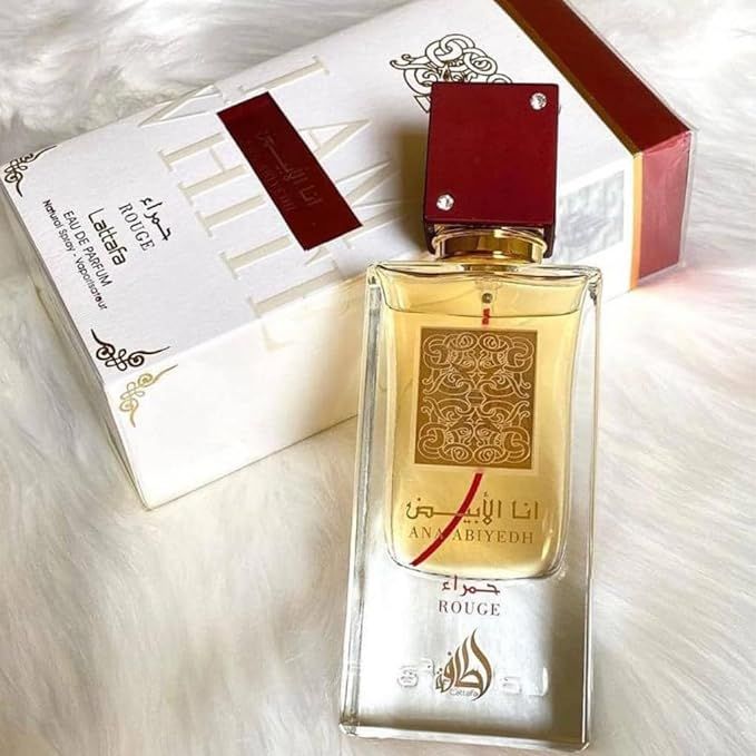 Refect Beauty Lattafa Ana Abiyedh Rouge Eau de Parfum bottle with a red cap and gold label on a white fur background.
