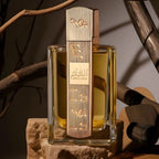 Refect Beauty Lattafa Angham Eau de Parfum bottle with gold musical note accents, set on stone against rustic branches.
