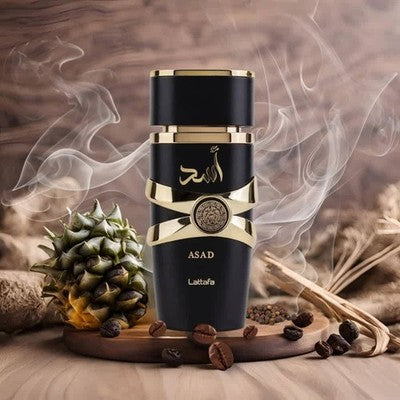 Refect Beauty Lattafa Asad Eau de Parfum bottle in black and gold, surrounded by pineapple, coffee beans, and smoke.