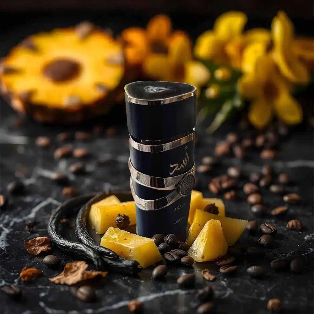 Refect Beauty Lattafa Asad Eau de Parfum bottle surrounded by pineapple slices, coffee beans, and vanilla pods.