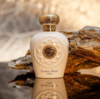Refect Beauty Lattafa Opulent Musk Eau de Parfum in a cream bottle with a gold textured cap on a rocky surface