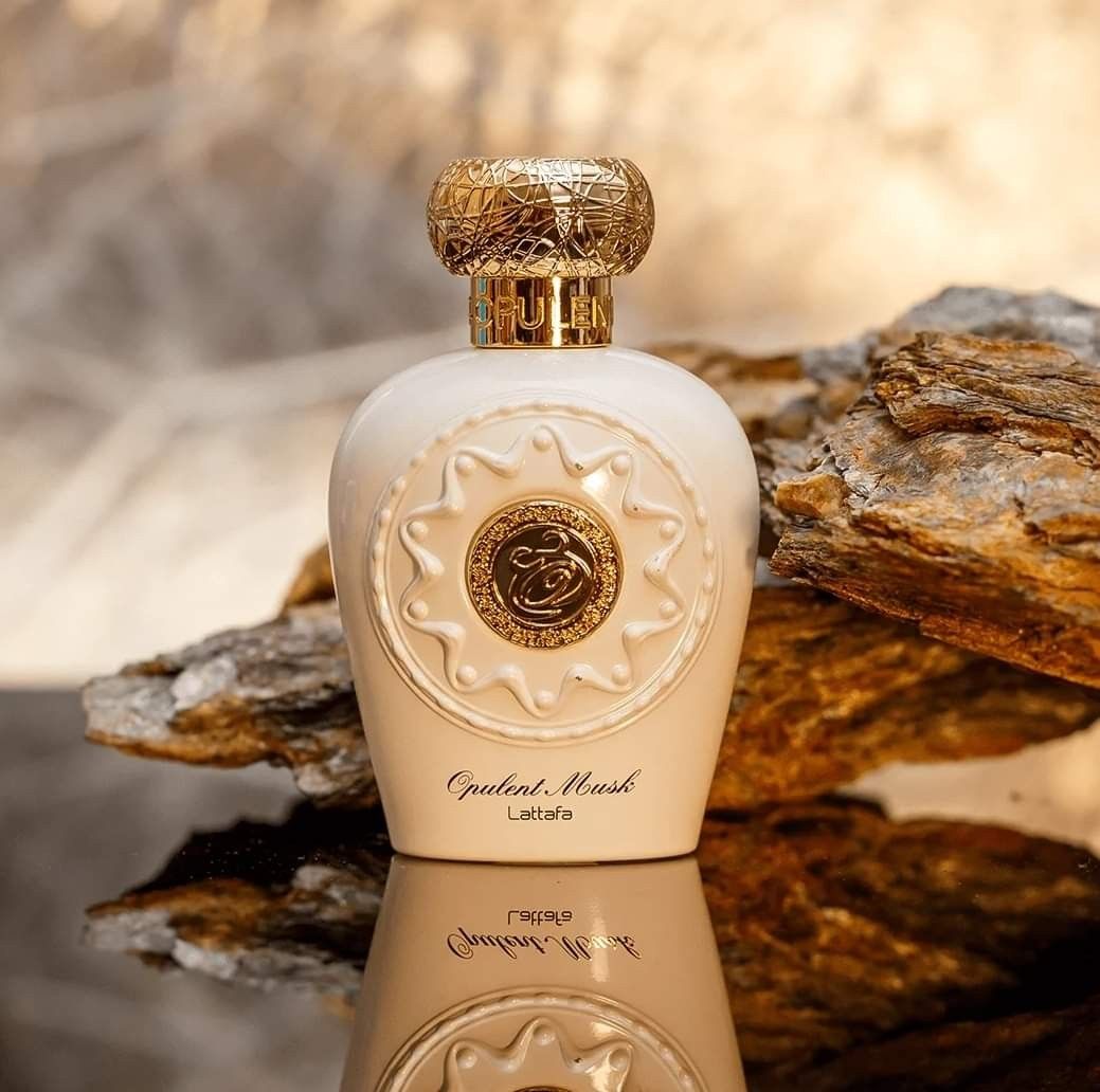 Refect Beauty Lattafa Opulent Musk Eau de Parfum in a cream bottle with a gold textured cap on a rocky surface