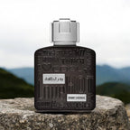 Refect Beauty Lattafa Ramz Silver Eau de Parfum bottle with embossed text on a stone against a mountain background