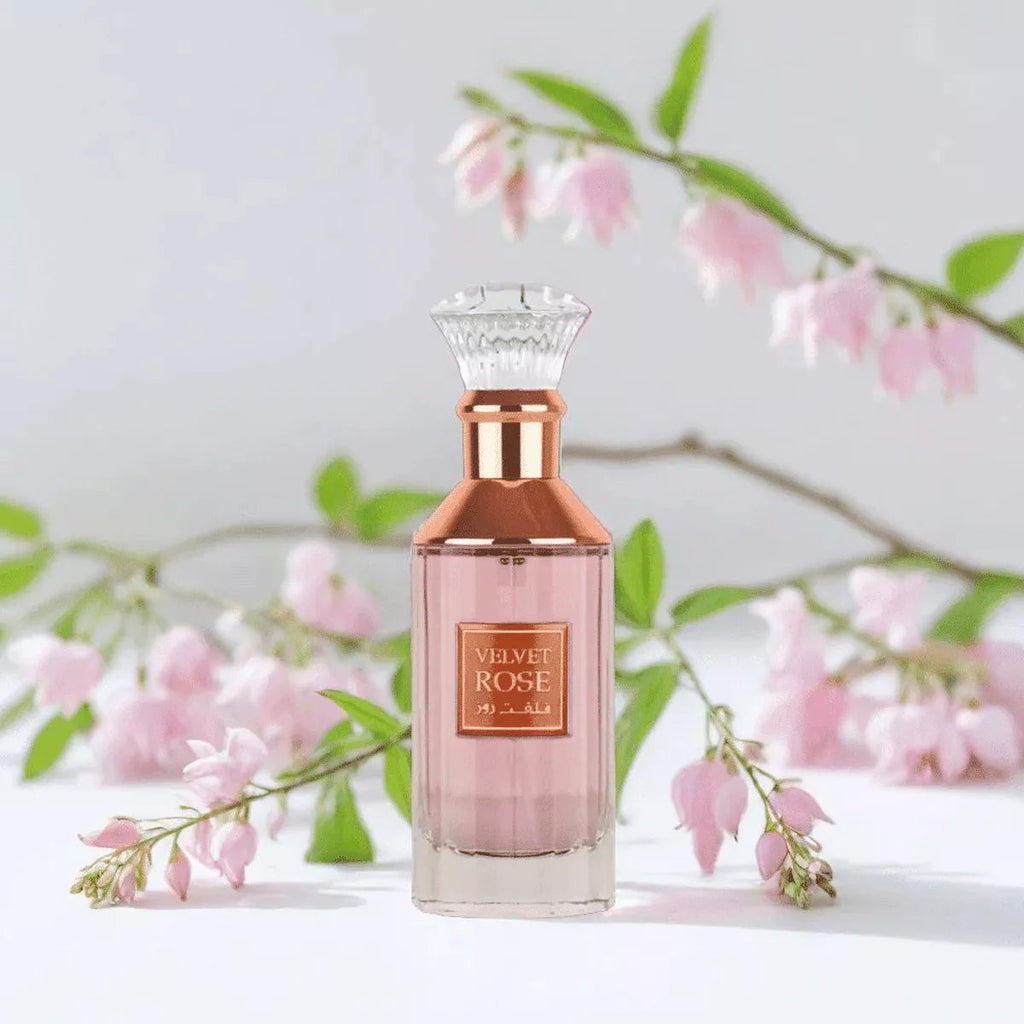 Refect Beauty Lattafa Velvet Rose eau de parfum in a glass bottle with a rose gold cap, set against pink flowers.