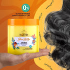 Refect Beauty Les Karites shea butter hair mask in a yellow jar held by a hand against a stylized background.