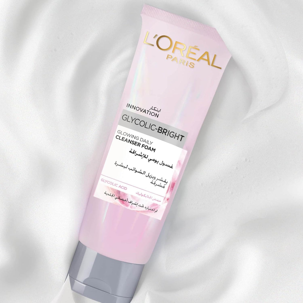 Refect Beauty L'Oreal Paris Glycolic Bright foaming cleanser in a light pink tube against a creamy white background.