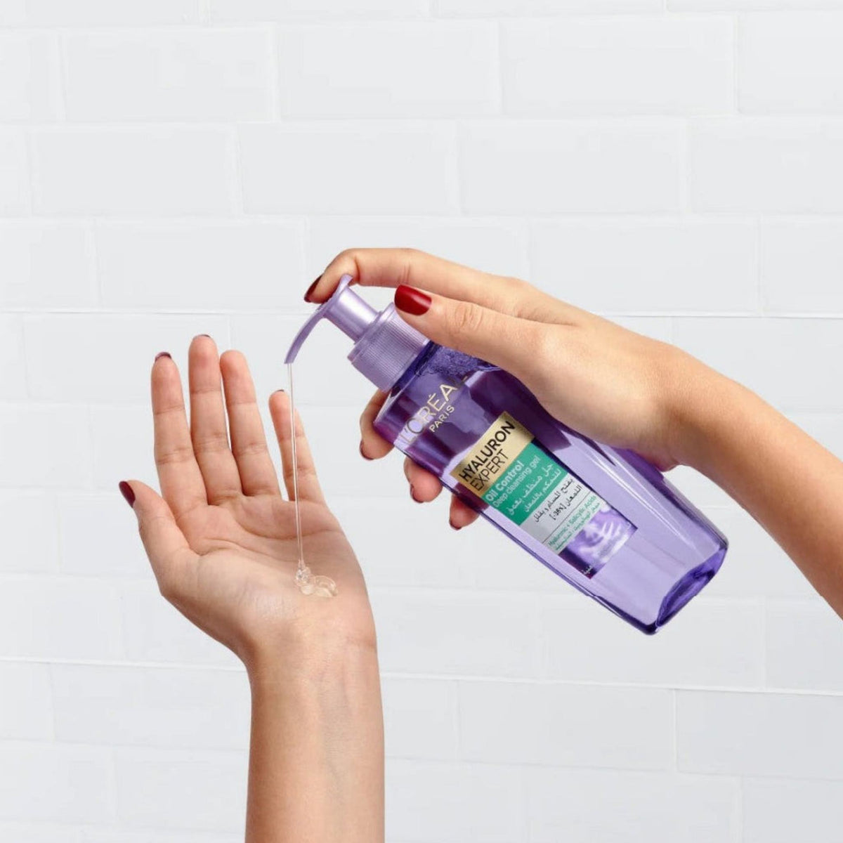 Refect Beauty L'Oreal Paris Hyaluron Expert deep cleansing gel being dispensed from a purple pump bottle into a hand