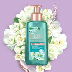 Refect Beauty Lux Purifying Watermint liquid hand wash in a teal bottle with a rose gold pump, surrounded by flowers.