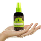 Refect Beauty Macadamia Natural Oil Healing Oil Spray held in a hand, featuring a brown bottle with a green pump.