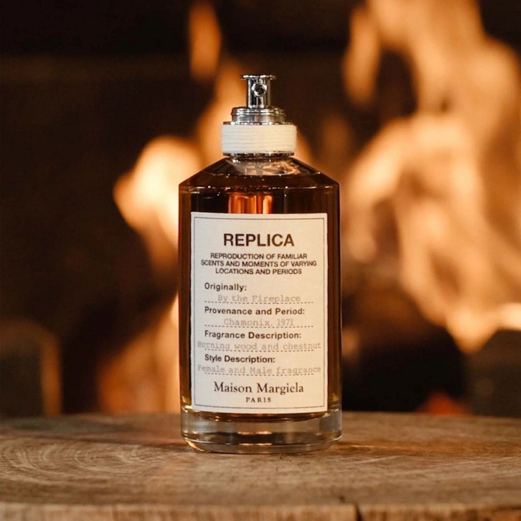 Refect Beauty Maison Margiela Replica By the Fireplace perfume bottle on a wooden surface with a glowing fire behind