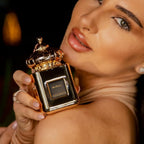 Refect Beauty Matin Martin Miral perfume bottle held by a woman, featuring a gold cap and elegant square design.