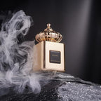 Refect Beauty Matin Martin Miral perfume bottle with a gold crown cap resting on a dark stone surrounded by smoke