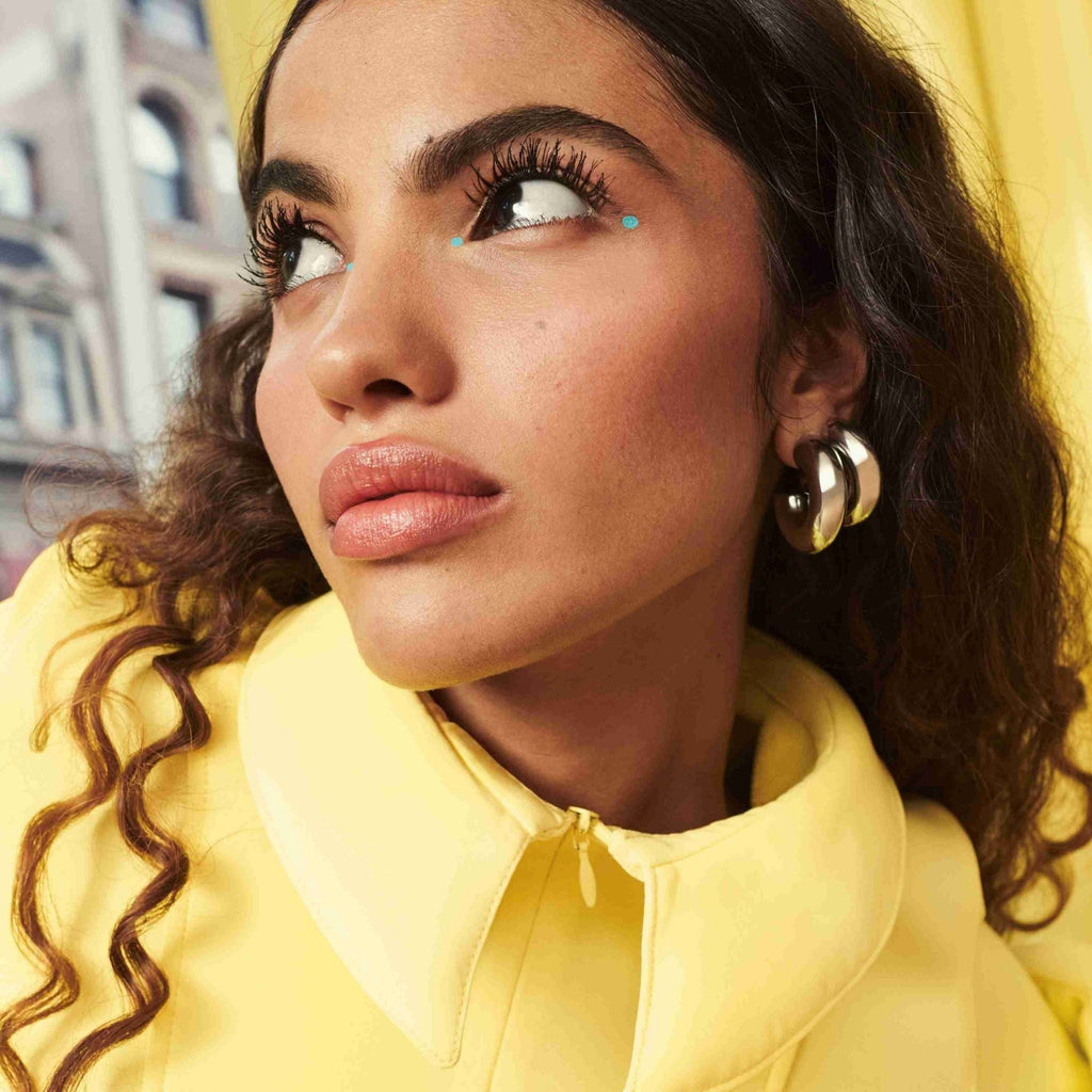 Refect Beauty model wearing Maybelline Colossal Bubble Mascara for voluminous, defined lashes in a bright setting