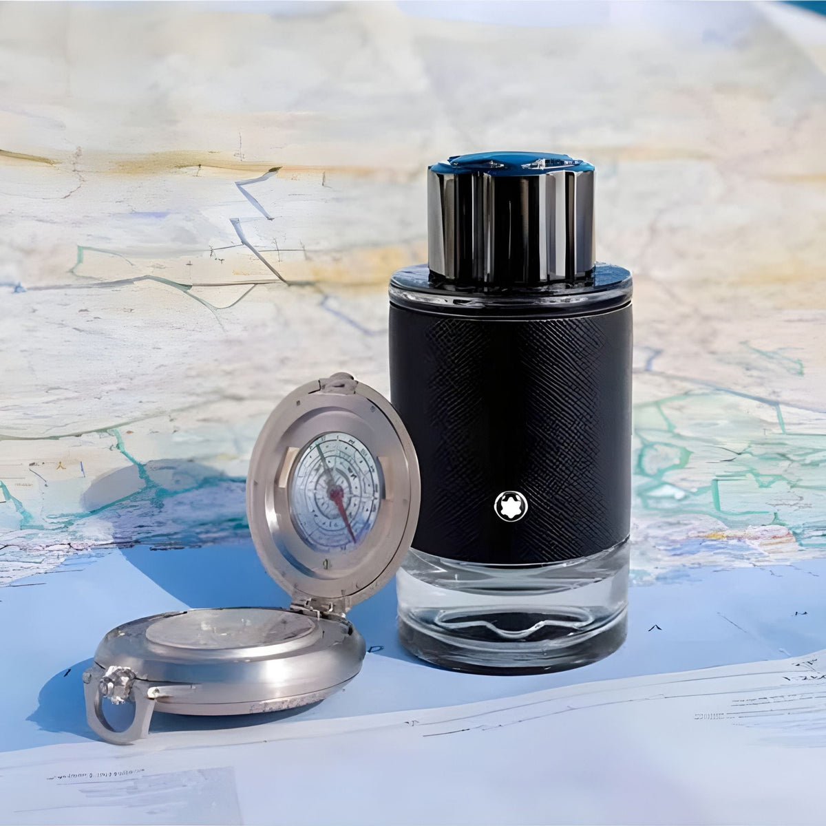 Refect Beauty Mont Blanc Explorer Eau de Parfum bottle next to a vintage metal compass on a map background