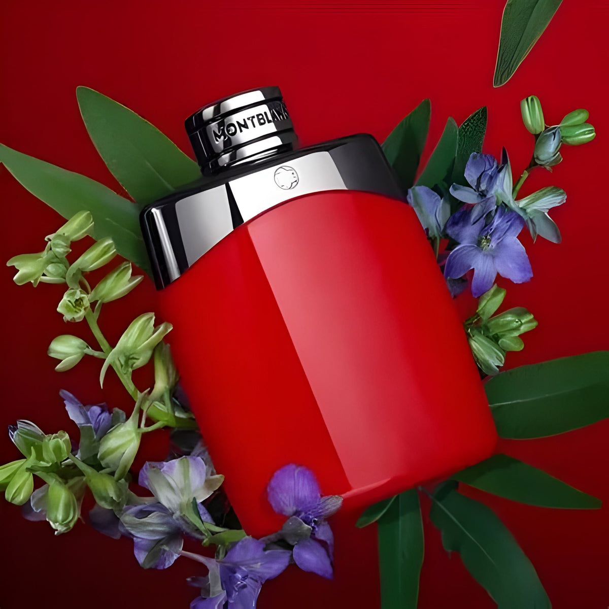 Refect Beauty Mont Blanc Legend Red Eau de Parfum bottle surrounded by green leaves and purple flowers on red background