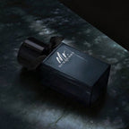 Refect Beauty Mr. Burberry Eau de Parfum in a dark glass bottle with a black ribbon on a dark marble surface.