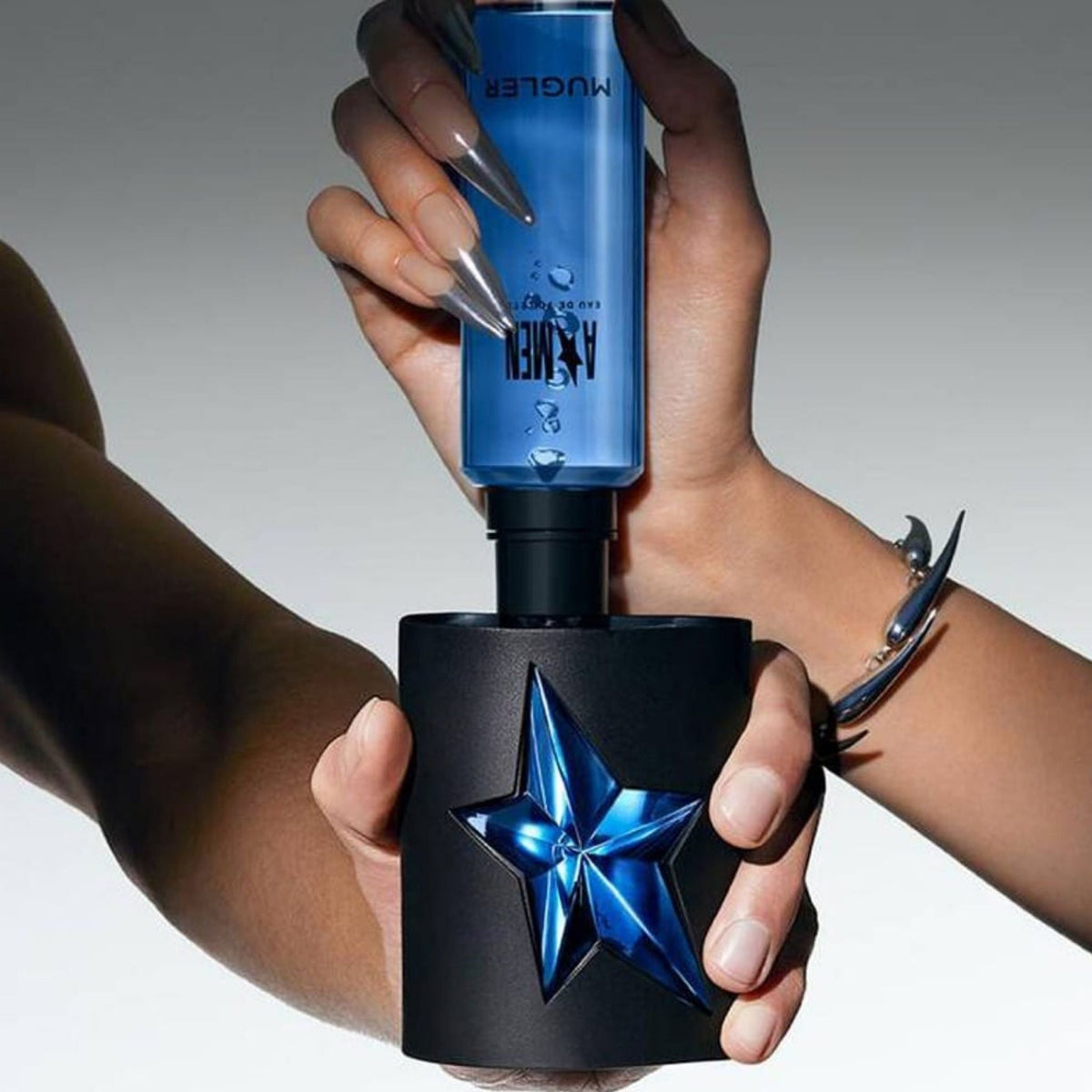 Refect Beauty Mugler A*Men refillable eau de toilette bottle being filled by a hand with long nails