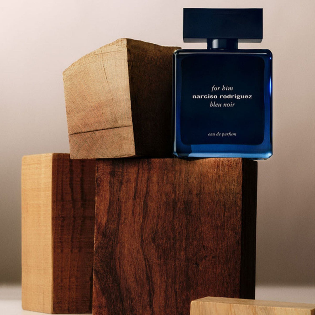 Refect Beauty Narciso Rodriguez For Him Bleu Noir Eau de Parfum bottle resting on rustic wooden blocks