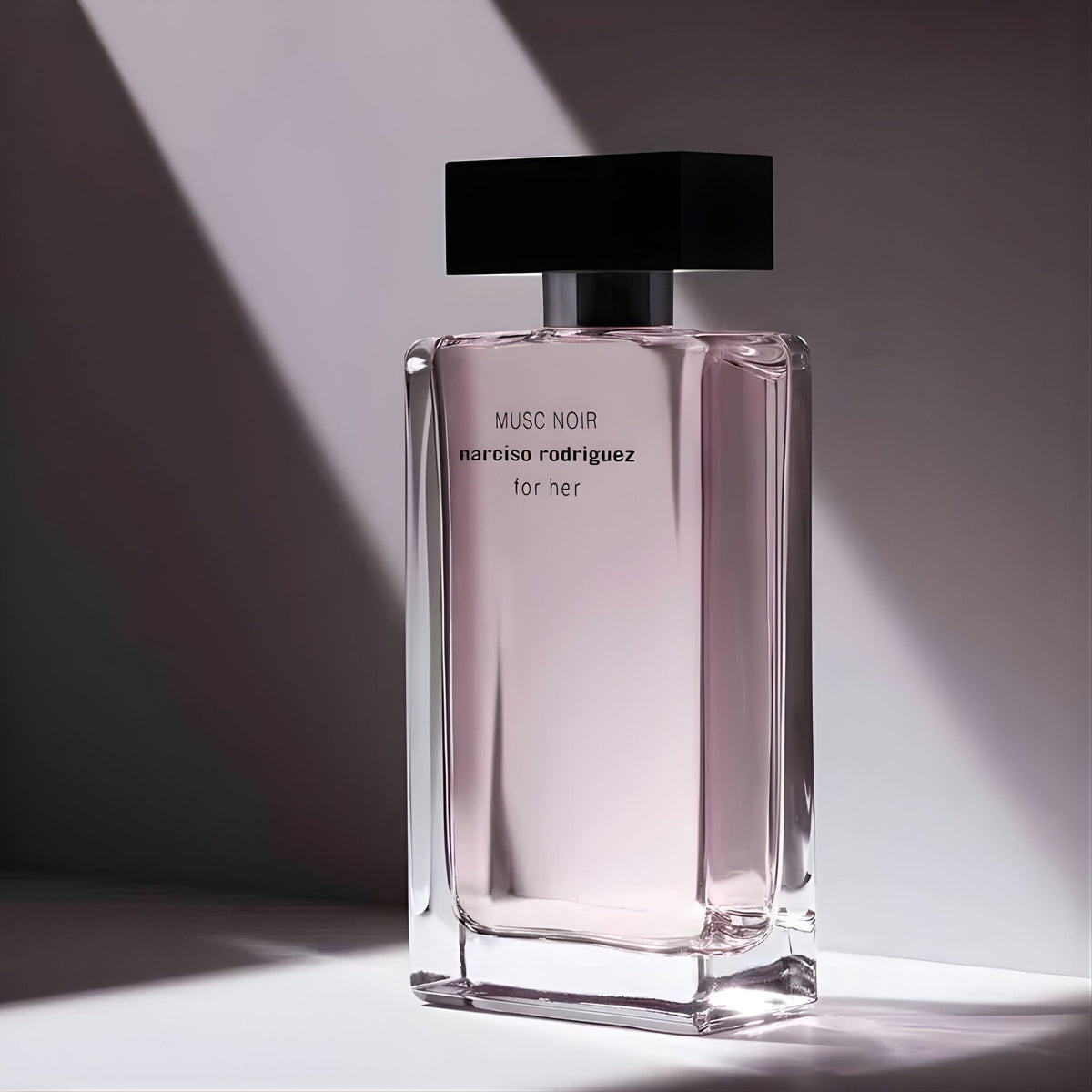 Refect Beauty Narciso Rodriguez Musc Noir for her perfume bottle with pink liquid and black cap in dramatic light