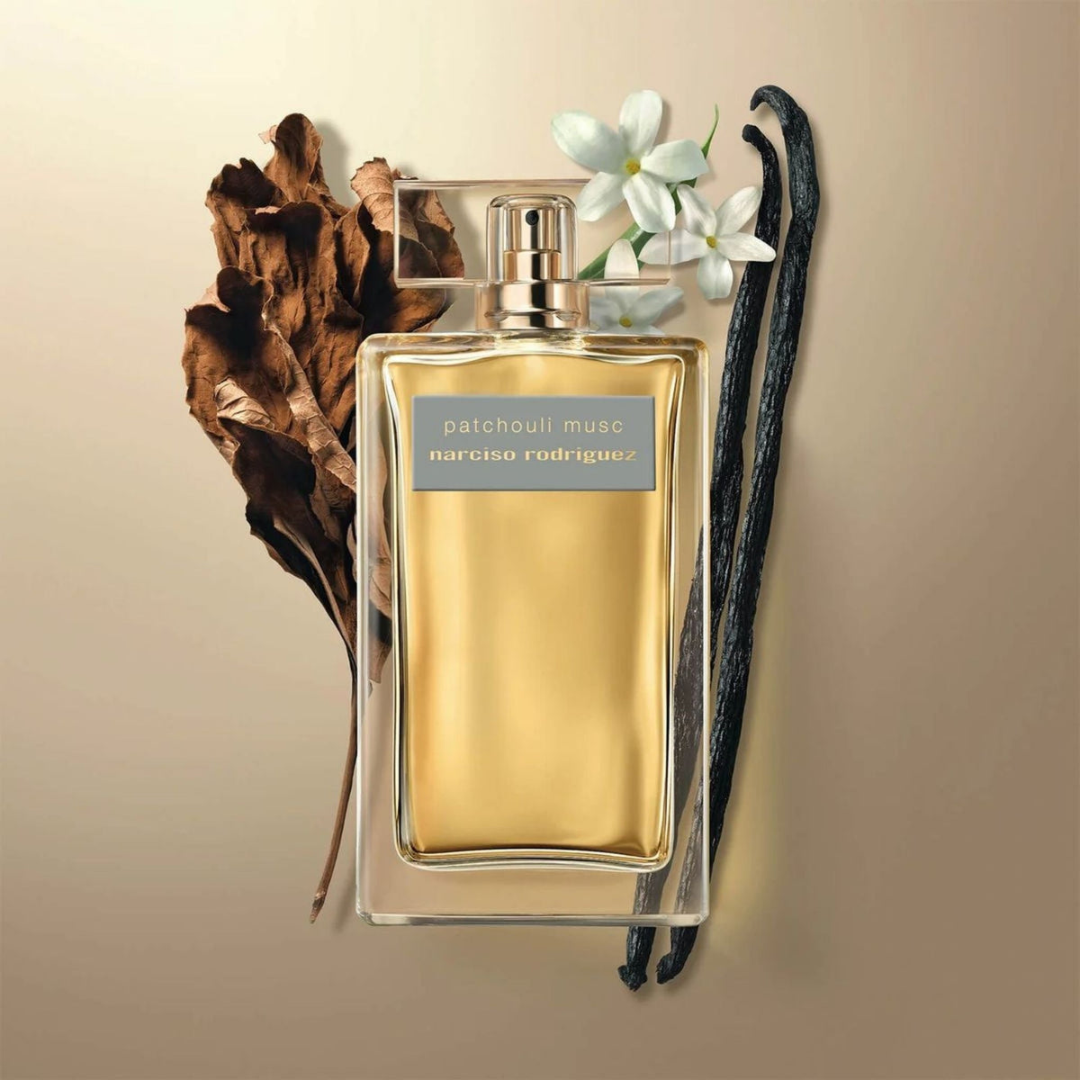 Refect Beauty Narciso Rodriguez Patchouli Musc perfume bottle surrounded by dried leaves, white flowers, and vanilla