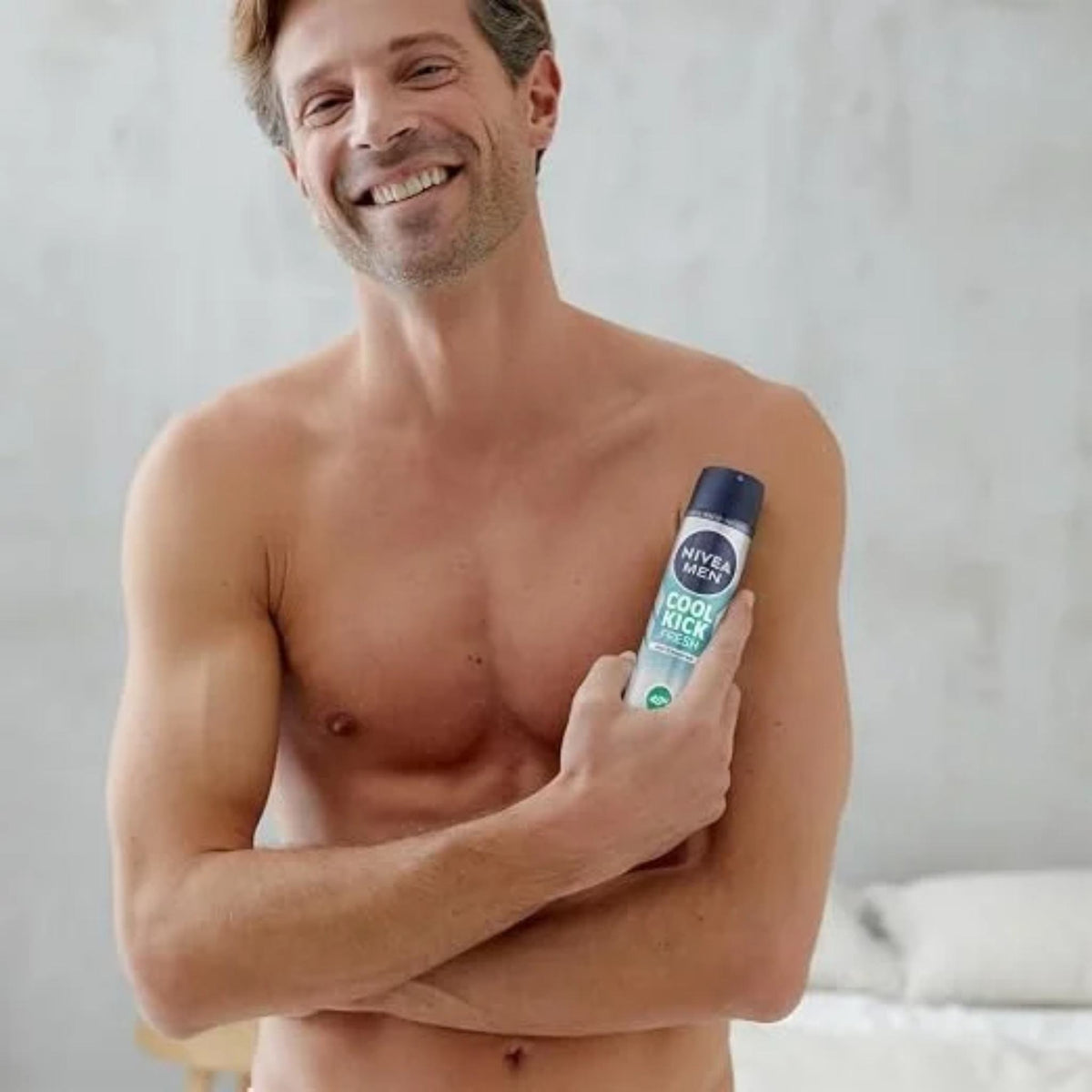 Refect Beauty smiling man holding a Nivea Men Cool Kick deodorant body spray for long-lasting freshness