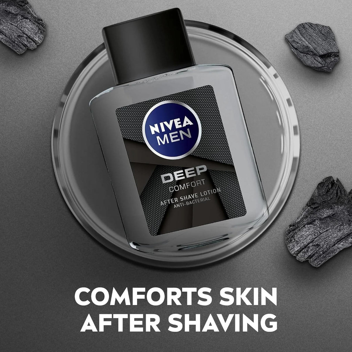 Refect Beauty Nivea Men Deep After Shave Lotion bottle on a glass surface surrounded by charcoal pieces