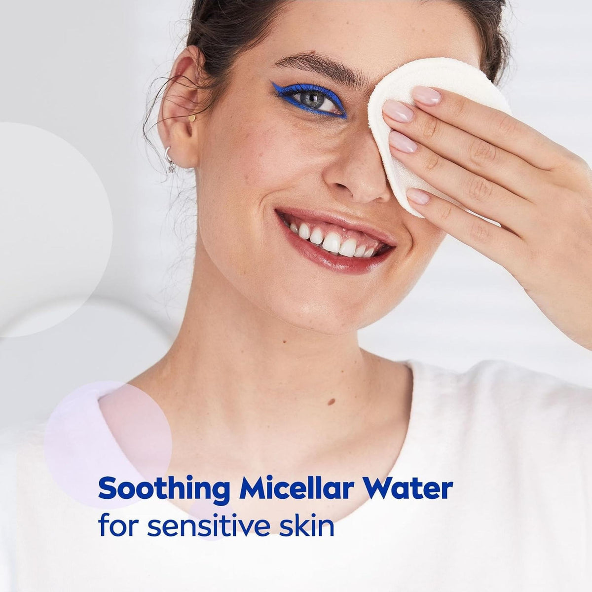 Refect Beauty model smiling while gently removing eye makeup with a cotton pad soaked in Nivea Soothing Micellar Water