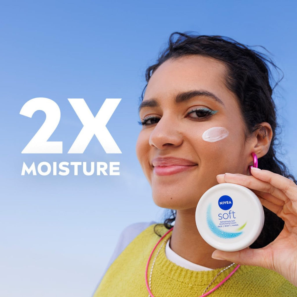 Refect Beauty model holding a white jar of Nivea Soft Refreshing Moisturizing Cream with cream applied to her cheek