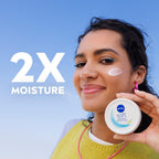 Refect Beauty model holding a white jar of Nivea Soft Refreshing Moisturizing Cream with cream applied to her cheek