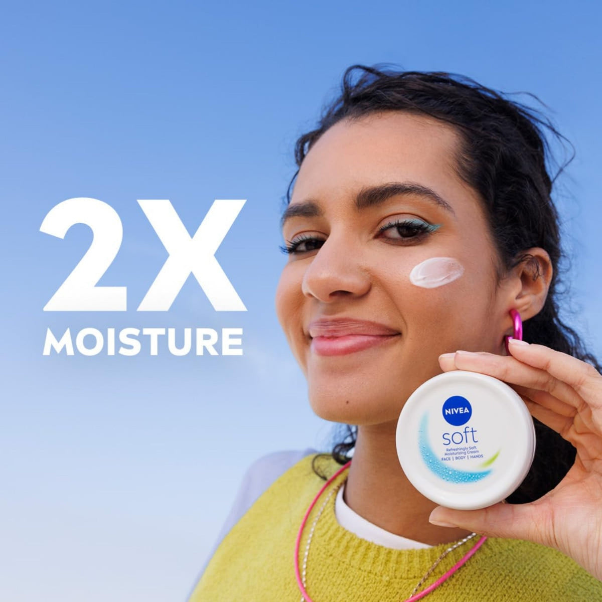 Refect Beauty model holding a white jar of Nivea Soft Refreshing Moisturizing Cream with cream applied to her cheek