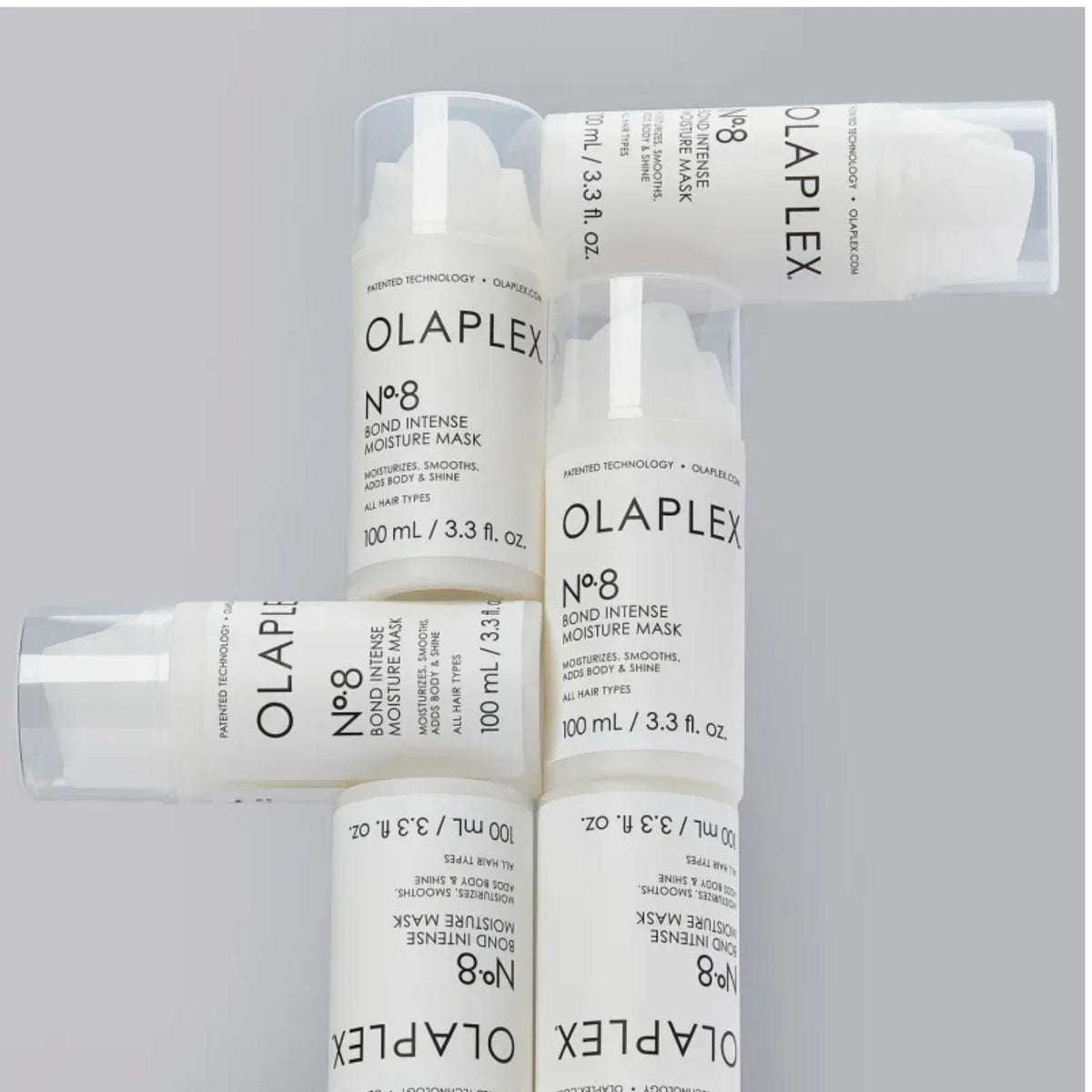 Refect Beauty Olaplex No.8 Bond Intense Moisture Mask bottles arranged in a cross pattern on a grey background.