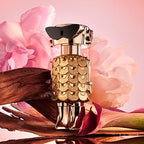 Refect Beauty Paco Rabanne Fame Eau de Parfum in a gold robot-shaped bottle surrounded by soft pink flowers.
