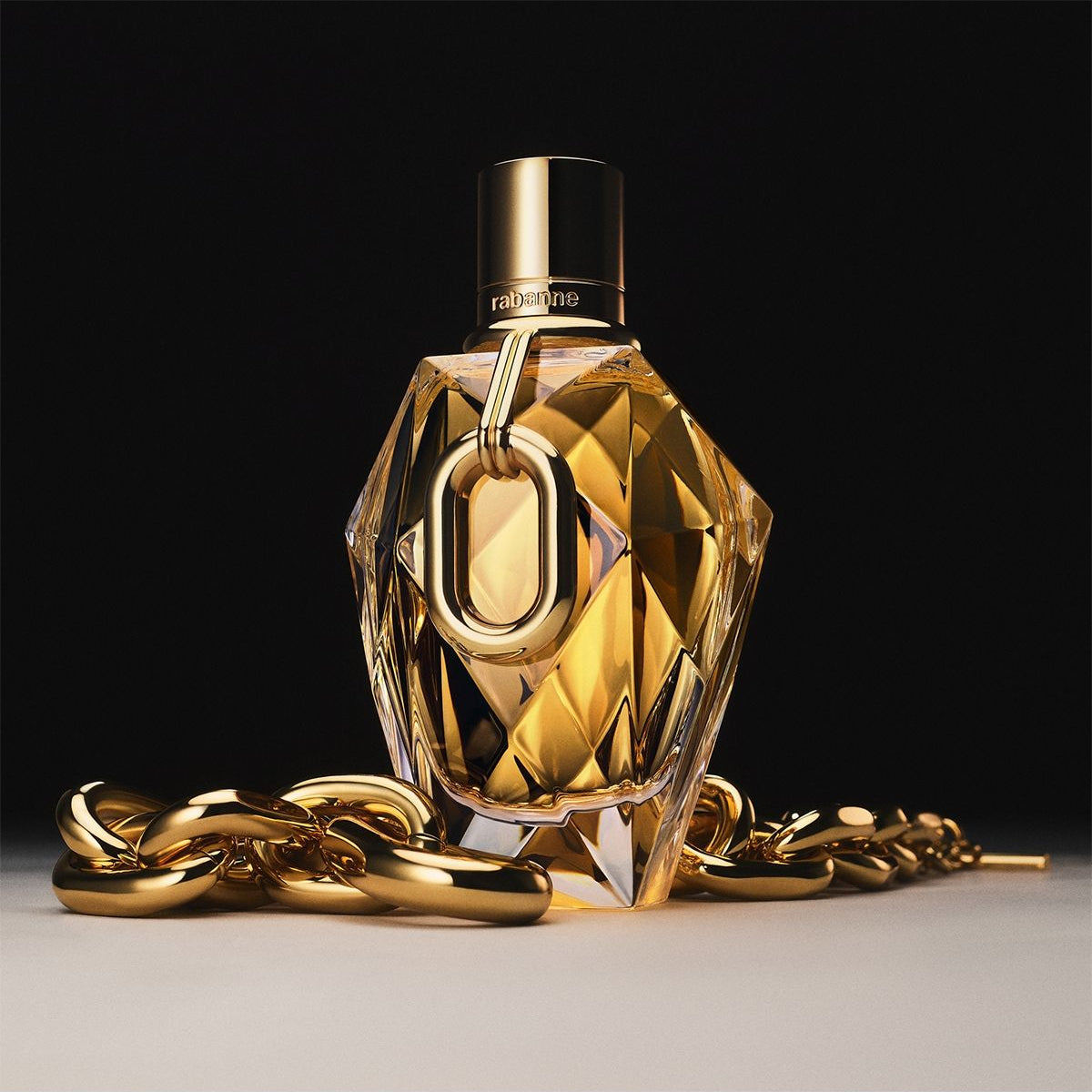 Refect Beauty Paco Rabanne Million Gold Eau de Parfum in a faceted gold bottle with a chain detail on a dark background