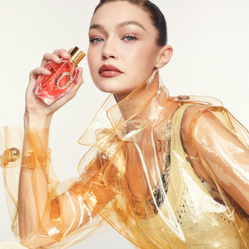 Refect Beauty model holding Paco Rabanne Million Gold Pure Diamonds perfume bottle in a translucent yellow jacket