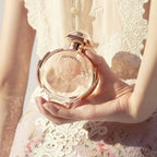 Refect Beauty Paco Rabanne Olympea Eau de Parfum bottle held in hand, featuring a rose gold cap and circular glass.