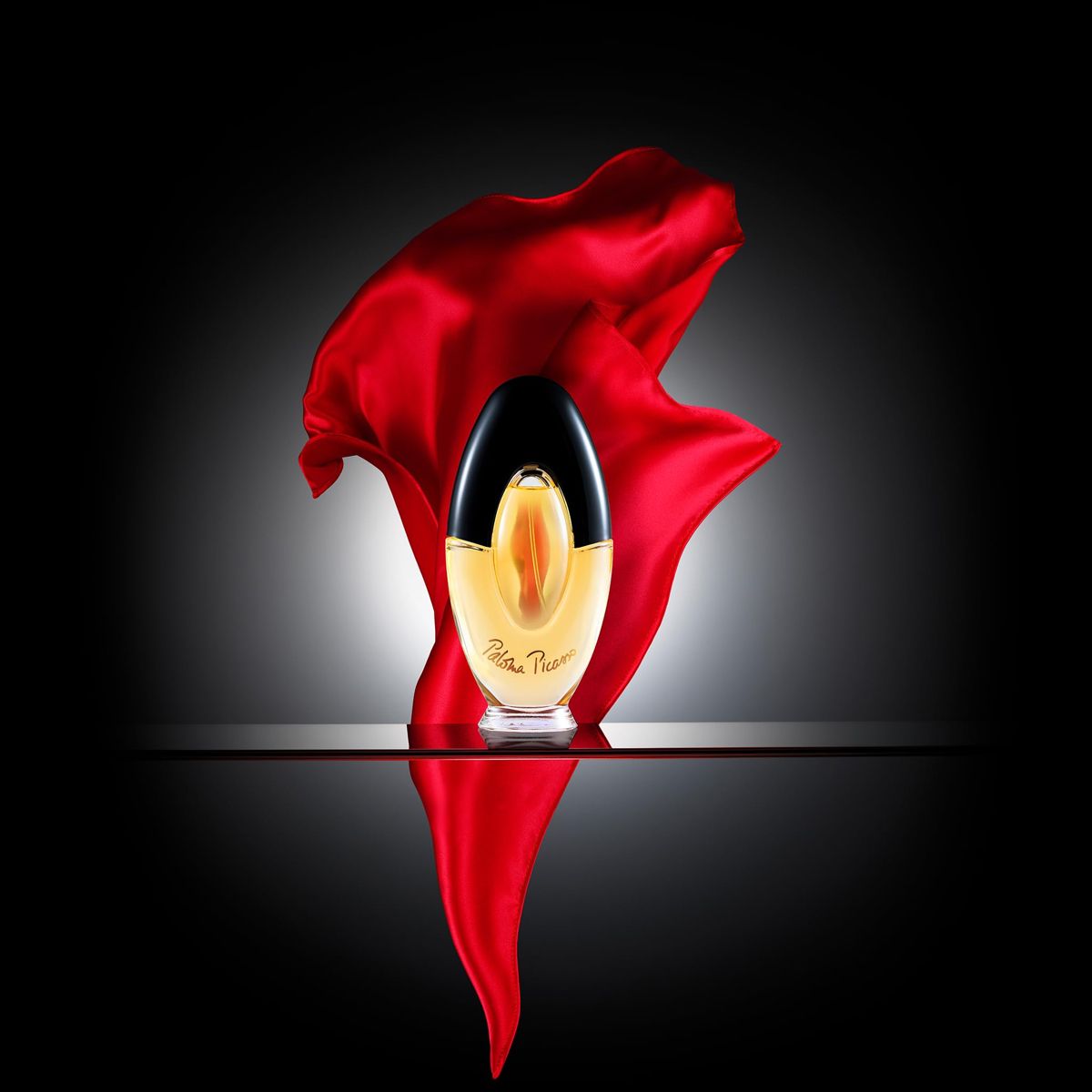 Refect Beauty Paloma Picasso Eau de Parfum bottle with a flowing red silk fabric against a dark background