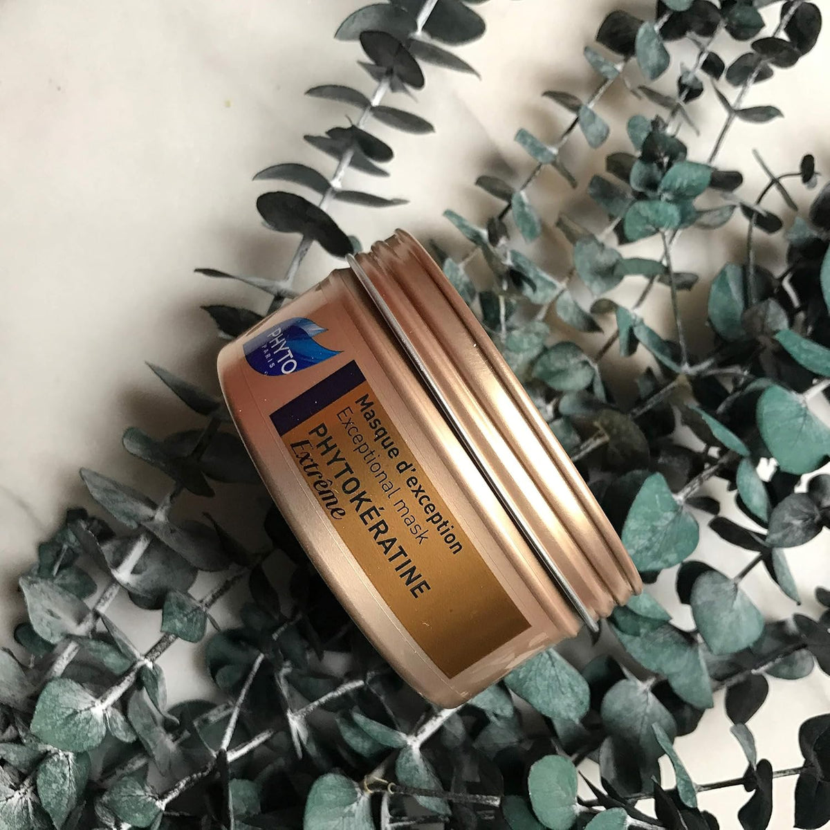 Refect Beauty Phyto Phytokeratine Extreme hair mask jar in gold packaging resting on decorative eucalyptus leaves